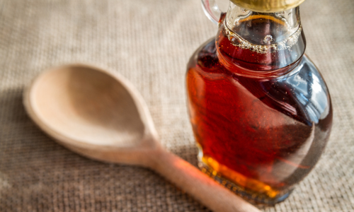A close-up of maple syrup and a stir stick.